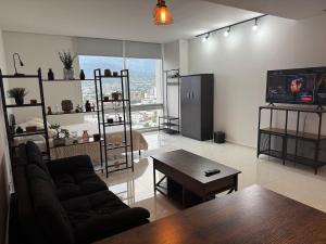 a living room with a couch and a table and a tv at Apartment with pool on Paseo Santa Lucia in Monterrey