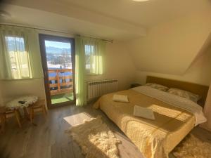 a bedroom with a bed and a large window at Kapacówka in Zakopane