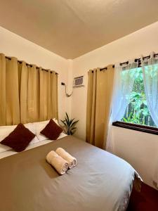 a bedroom with a large bed with a window at Paians 2BR Home, across Cloud 9, General Luna in Catangnan +10 photos