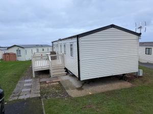 a small white shed with a porch in a yard at The Ellerton at Eyemouth in Eyemouth