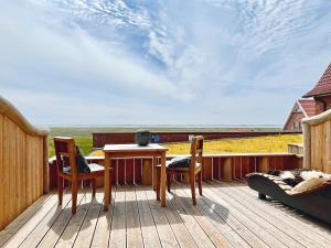 a table and chairs on a deck with a view at Hotel Fresena in Baltrum