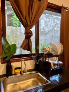 a kitchen sink with a window and a kitchen counter at Paians 2BR Home, across Cloud 9, General Luna in Catangnan