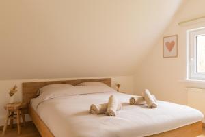 a white bed with two pillows on top of it at Escapade Boisée in Vencimont