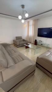a living room with a couch and a tv at Mubi House in Kinshasa