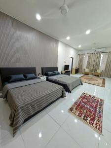 a bedroom with two beds and a rug at Kamar Musafir MMS in Ipoh