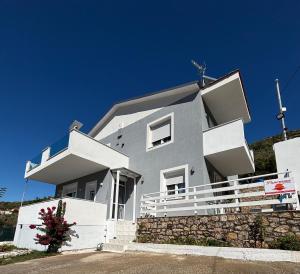 a white house with a stone wall at Panorama Apartments in Prinos