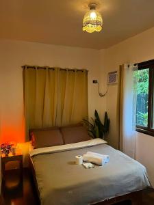 a bedroom with a bed with a lamp and a window at Paians 2BR Home, across Cloud 9, General Luna in Catangnan