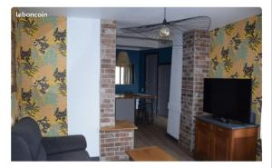 a living room with a couch and a television at Maison Terreaux in Vaux-en-Bugey