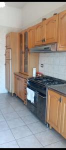 a kitchen with wooden cabinets and a stove top oven at la casa di Titty con wi fi in Avellino