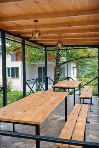 two picnic tables under a wooden pergola at olya's garden in Tsʼageri +37 photos