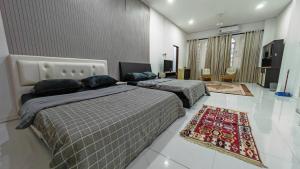 a bedroom with two beds and a rug on the floor at Kamar Musafir MMS in Ipoh +23 photos
