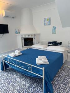 a bedroom with a blue bed with towels on it at Pennadio Rooms in Bacoli