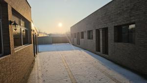 an empty alley between two buildings with the sun in the background at Pensiunea Casa Bianca-Târgu Jiu in Târgu Jiu +10 photos