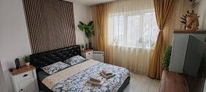a bedroom with a bed and a television and a window at Abel Luxury Home in Constanţa