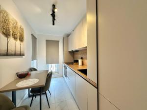 a kitchen with a table and a small table and chairs at Aurora Premium Cosmopolis in Tunari