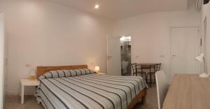 a bedroom with a bed and a table and chairs at Cinghiale Bianco in Cagliari