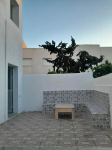 a bench with a table in front of a building at CHEZ ALAA Kelibia in Kelibia