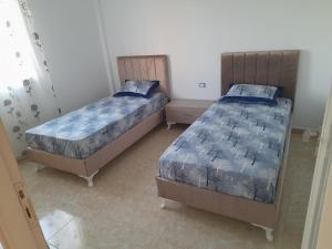 two twin beds in a room with at CHEZ ALAA Kelibia in Kelibia