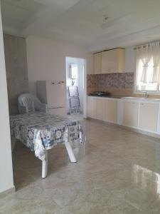 a living room with a table and a kitchen at CHEZ ALAA Kelibia in Kelibia