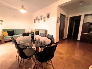 a dining room with a glass table and black chairs at Gulbenkian 39 in Vila Nova de Gaia
