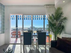 a living room with a table and chairs and a large window at Urban Waves by Hello Homes Sitges in Sitges