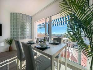 a dining room with a table and a large window at Urban Waves by Hello Homes Sitges in Sitges