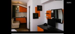 a kitchen with orange cabinets and a desk with a computer at Златоград in Zlatograd