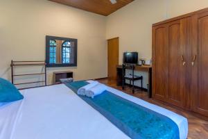 a bedroom with a bed and a desk and a television at Bungalow 36 in Kandy