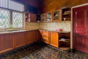 a kitchen with wooden cabinets and a sink and a window at Bungalow 36 in Kandy