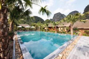 a pool at a resort with mountains in the background at The Bổi Heritage Tam Coc in Ninh Binh