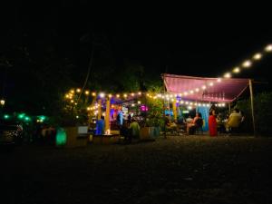 a group of people sitting outside a tent at night at New Western Llanos Stay in Acacías