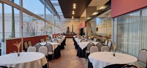 a row of tables in a room with windows at Trade Hotel in Juiz de Fora