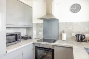 a kitchen with white appliances and a clock on the wall at Self Catering Accommodation - Balivanich, Sleeps 6 in Balivanich +20 photos