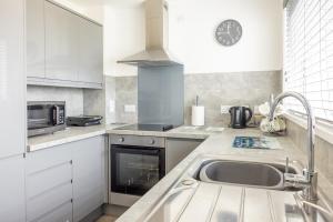 a kitchen with a sink and a microwave at Self Catering Accommodation - Balivanich, Sleeps 6 in Balivanich