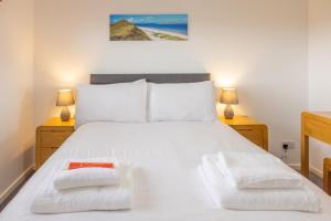 a bedroom with a white bed with two night stands at Self Catering Accommodation - Balivanich, Sleeps 6 in Balivanich