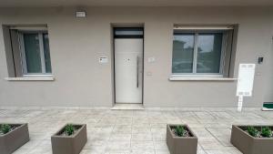 a building with two potted plants in front of a door at Borgo San Michele Bed & Breakfast in Calvisano