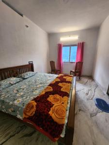 a bedroom with a bed with a quilt on it at Brooklyn Homestay in Vattavada