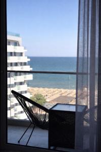 a chair sitting on a balcony with a view of the ocean at Waves 342 Infinity in Mamaia Sat/Năvodari