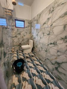 a bathroom with a toilet and a marble wall at Brooklyn Homestay in Vattavada +10 photos