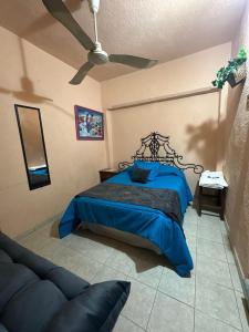 a bedroom with a blue bed and a ceiling fan at Hotel Los Reyes in Córdoba