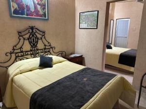 a hotel room with two beds and a mirror at Hotel Los Reyes in Córdoba
