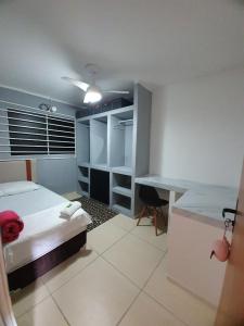 a bedroom with a bed and a desk in it at Bedroom Airport in Maceió