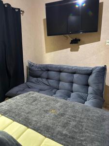 a blue couch with a flat screen tv on a wall at Hotel Los Reyes in Córdoba