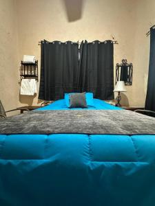 a large blue bed in a room with black curtains at Hotel Los Reyes in Córdoba