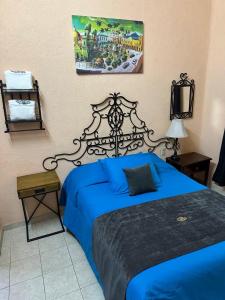 a bedroom with a bed with a blue comforter at Hotel Los Reyes in Córdoba +23 photos