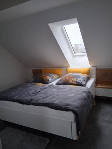 a bedroom with a bed in a attic with a window at Auszeit in Storkow