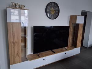 a tv on a wall with a clock on the wall at Auszeit in Storkow