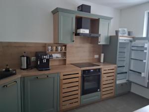 a kitchen with green cabinets and a stove top oven at Auszeit in Storkow