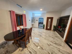 a dining room with a wooden table and chairs at Brooklyn Homestay in Vattavada