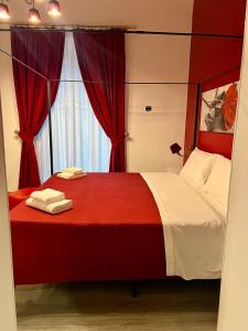 a bedroom with a red and white bed with a window at Duca di Uzeda Bed and Breakfast in Catania